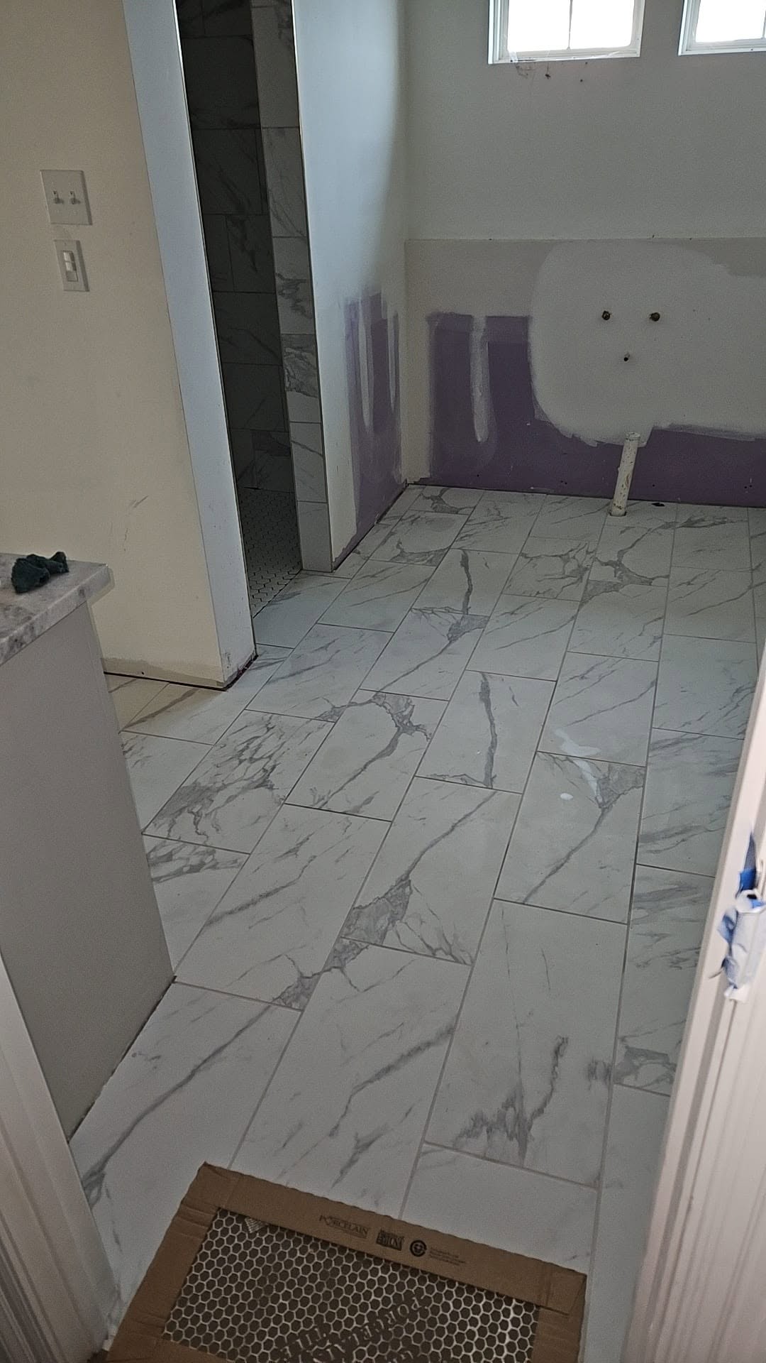 Large-format marble-look tile flooring installation by Floor Masters of Acadiana.
