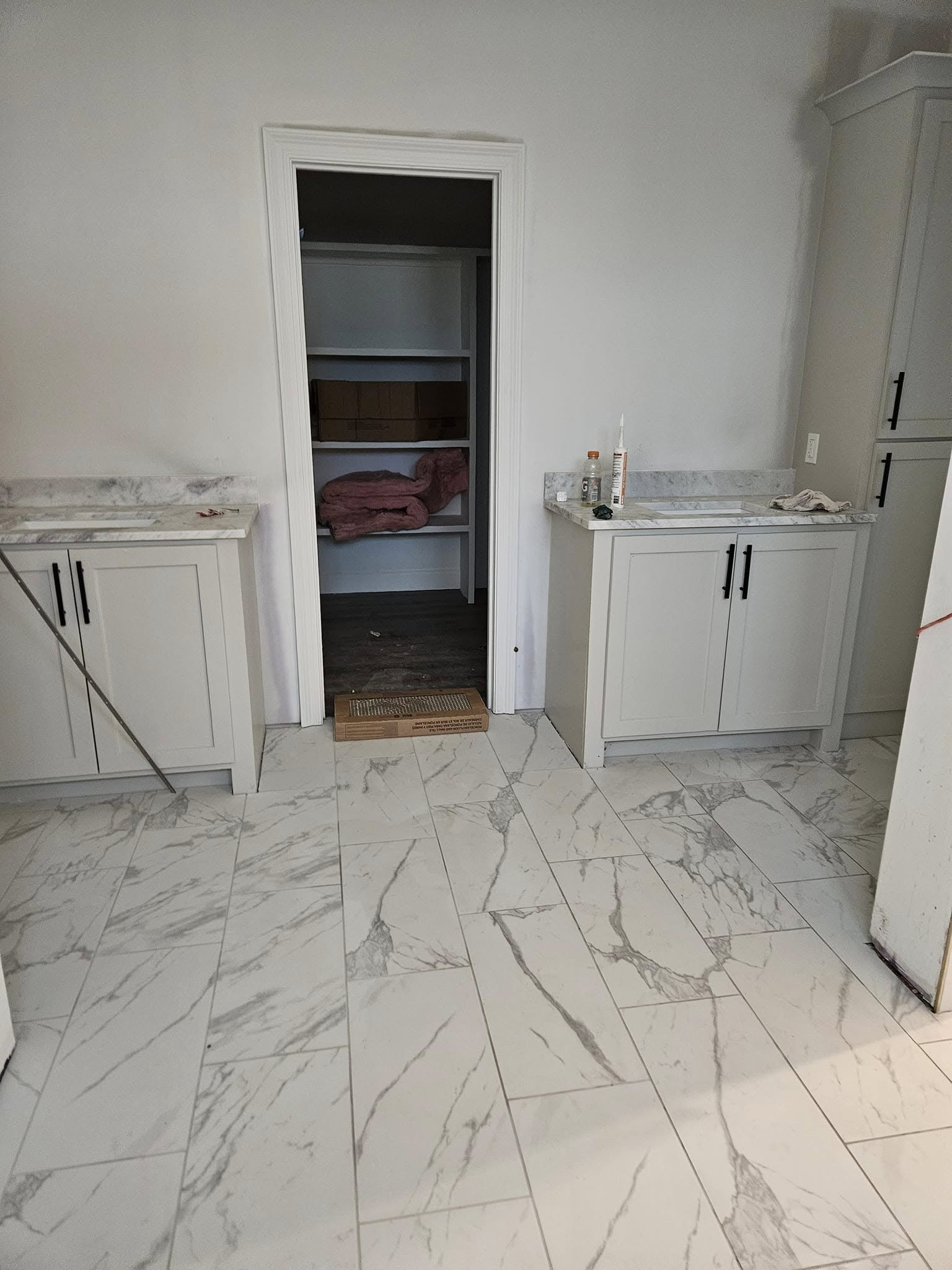 Luxury bathroom remodel featuring marble tile flooring and custom cabinetry by Floor Masters of Acadiana.
